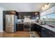 Modern kitchen with dark cabinetry, granite counters, and stainless steel appliances at 9485 Joyce Ln, Highlands Ranch, CO 80126