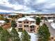 Luxury home with backyard patio, surrounded by snow-covered trees at 1365 Gentry Pl, Castle Rock, CO 80104