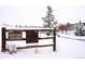 Snowy open space entrance with a wooden fence and signage at 1365 Gentry Pl, Castle Rock, CO 80104