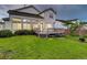 Charming backyard featuring a lush lawn, mature tree, deck with outdoor access, and exterior view of the home at 15498 E Dorado Pl, Centennial, CO 80015