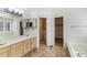 Bathroom with vanity, large mirror, and separate tub and toilet areas at 15498 E Dorado Pl, Centennial, CO 80015
