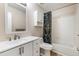 Bright bathroom features a tub and shower, white vanity, framed mirror, and attractive geometric patterned shower curtain at 15498 E Dorado Pl, Centennial, CO 80015