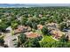 Aerial view of a neighborhood showing several condos with brown roofs, trees, lawns, and road at 8422 Everett Way # C, Arvada, CO 80005