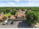 Aerial view of the tan condo complex with a brown roof, garages, trees, and lawn on a clear day at 8422 Everett Way # C, Arvada, CO 80005