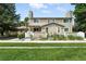 Charming townhome featuring a stone chimney, well-kept lawn, and inviting curb appeal at 8422 Everett Way # C, Arvada, CO 80005