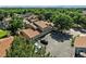 Aerial view of the tan condo complex with a brown roof, garages, trees, and lawn on a clear day at 8422 Everett Way # C, Arvada, CO 80005