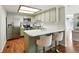 Modern kitchen with stainless steel appliances, sleek countertops, stylish stools, and bright lighting at 8422 Everett Way # C, Arvada, CO 80005