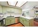 Well-lit kitchen with stainless steel appliances, light green cabinets, and a view into the cozy living area at 8422 Everett Way # C, Arvada, CO 80005