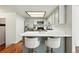 Modern kitchen with stainless steel appliances, sleek countertops, stylish stools, and bright lighting at 8422 Everett Way # C, Arvada, CO 80005