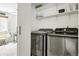 Bright laundry room features modern washer and dryer, with shelving for storage and easy access to other rooms at 8422 Everett Way # C, Arvada, CO 80005