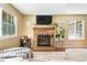 Cozy living room featuring a brick fireplace, large windows, and comfortable seating at 8422 Everett Way # C, Arvada, CO 80005
