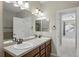 Bright bathroom with double sinks, and a view to a bedroom through the door at 31112 Black Eagle Dr # 103, Evergreen, CO 80439