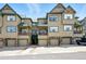 Inviting townhome complex with private garages, covered decks and charming stone accents against blue skies at 31112 Black Eagle Dr # 103, Evergreen, CO 80439