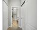 Hallway leading to a bathroom with tiled floors and multiple closet doors at 31112 Black Eagle Dr # 103, Evergreen, CO 80439