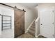 Hallway featuring wood look flooring, a sliding barn door, and a carpeted staircase at 31112 Black Eagle Dr # 103, Evergreen, CO 80439