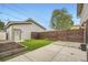 Backyard showcasing artificial turf, garden beds, concrete patio, and wooden fence at 2442 S Bannock St, Denver, CO 80223