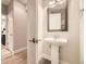 Powder room featuring a pedestal sink, stylish mirror, and modern fixtures at 2442 S Bannock St, Denver, CO 80223