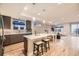 Open-concept kitchen with island, stainless steel appliances, and hardwood floors at 2442 S Bannock St, Denver, CO 80223