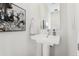Modern half bathroom with pedestal sink, framed mirror, and neutral decor at 3414 W 18Th Ave, Denver, CO 80204