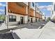 Modern townhomes with wood and white exteriors line a concrete walkway with wrought iron railing at 3414 W 18Th Ave, Denver, CO 80204