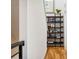 Bright hallway featuring hardwood floors and a decorative bookshelf with plants and artwork at 3414 W 18Th Ave, Denver, CO 80204