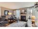 Comfortable living room with stylish armchairs, a decorative fireplace, and natural light from a large window at 3798 E 118Th Way, Thornton, CO 80233