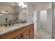 Bright bathroom showcasing double vanity, granite countertop, tiled shower, and an open doorway at 420 Sunshine Pkwy, Golden, CO 80403