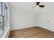 This bedroom has a ceiling fan, wood-look floors, a large window, and a double sliding-door closet at 9120 E Girard Ave # 12, Denver, CO 80231