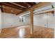 Spacious unfinished basement featuring exposed wood beam accents and durable flooring at 2414 Winding Dr, Longmont, CO 80504