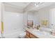 Bright bathroom features a shower-tub combo with white tile, light wood vanity, and neutral decor at 2414 Winding Dr, Longmont, CO 80504