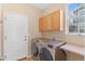 Cozy laundry room with modern washer and dryer, bright window, and extra storage at 2414 Winding Dr, Longmont, CO 80504