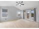 Bright living room with neutral carpet, ceiling fan, large windows, and access to a balcony at 2414 Winding Dr, Longmont, CO 80504
