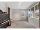 Cozy living room with large windows and a classic piano at 2414 Winding Dr, Longmont, CO 80504