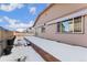 A snowy backyard with a wood fence, raised garden, and tan home siding, set under a bright sky at 25127 E Maple Ave, Aurora, CO 80018