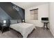 Inviting bedroom featuring a modern design with a unique wall design, complemented by a window and dark furniture at 25127 E Maple Ave, Aurora, CO 80018