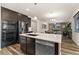 Modern kitchen with dark wood cabinets, stainless steel appliances, and an open layout to the living area at 25127 E Maple Ave, Aurora, CO 80018