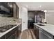Well-equipped kitchen featuring dark wood cabinets, stainless steel appliances, and a tile backsplash at 25127 E Maple Ave, Aurora, CO 80018