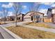 A charming single-Gathering home boasts a well-manicured lawn, complemented by mature trees and a neatly paved driveway at 25127 E Maple Ave, Aurora, CO 80018