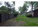 A fenced backyard with ample green space, landscaping features and mature trees at 1703 W Weaver Ave, Littleton, CO 80120