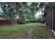 A large fenced backyard with mature trees, greenery and a lounge chair for relaxation at 1703 W Weaver Ave, Littleton, CO 80120
