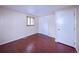 Cozy bedroom with wood-look floors, a closet, and a large window for natural light at 1703 W Weaver Ave, Littleton, CO 80120