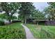 Lush front lawn with a walkway and mature trees leading to the front of the cozy home at 1703 W Weaver Ave, Littleton, CO 80120
