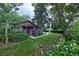 A view of the cozy home with mature trees and walkway leading to the front entrance at 1703 W Weaver Ave, Littleton, CO 80120