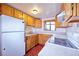 Efficient kitchen with white appliances, wood cabinets, and plenty of counter space for meal preparation at 1703 W Weaver Ave, Littleton, CO 80120