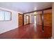 Open living room with wood-look floors, wood-paneled walls, and a sliding glass door to the backyard at 1703 W Weaver Ave, Littleton, CO 80120