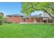 Expansive backyard featuring a well-maintained lawn, a brick house, and an inviting patio with a grill at 503 Lois Dr, Louisville, CO 80027