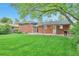Spacious backyard with a well-maintained lawn, a brick house, and an inviting patio with a grill at 503 Lois Dr, Louisville, CO 80027