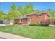 Traditional brick home boasts a well-manicured lawn, mature landscaping, and a welcoming front entrance at 503 Lois Dr, Louisville, CO 80027