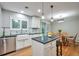 Stylish kitchen with white cabinets, an island, and an adjacent dining area with natural light at 503 Lois Dr, Louisville, CO 80027