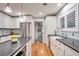 Updated kitchen featuring white cabinets, a farmhouse sink, and modern lighting fixtures at 503 Lois Dr, Louisville, CO 80027